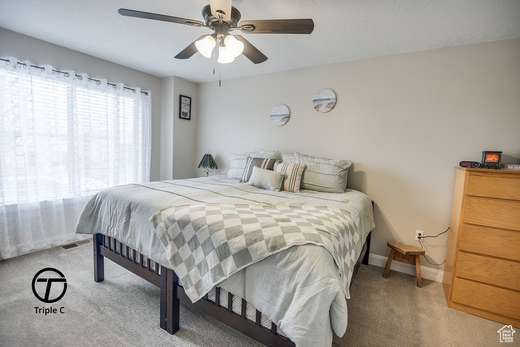 Bedroom with carpet, baseboards, and a ceiling fan