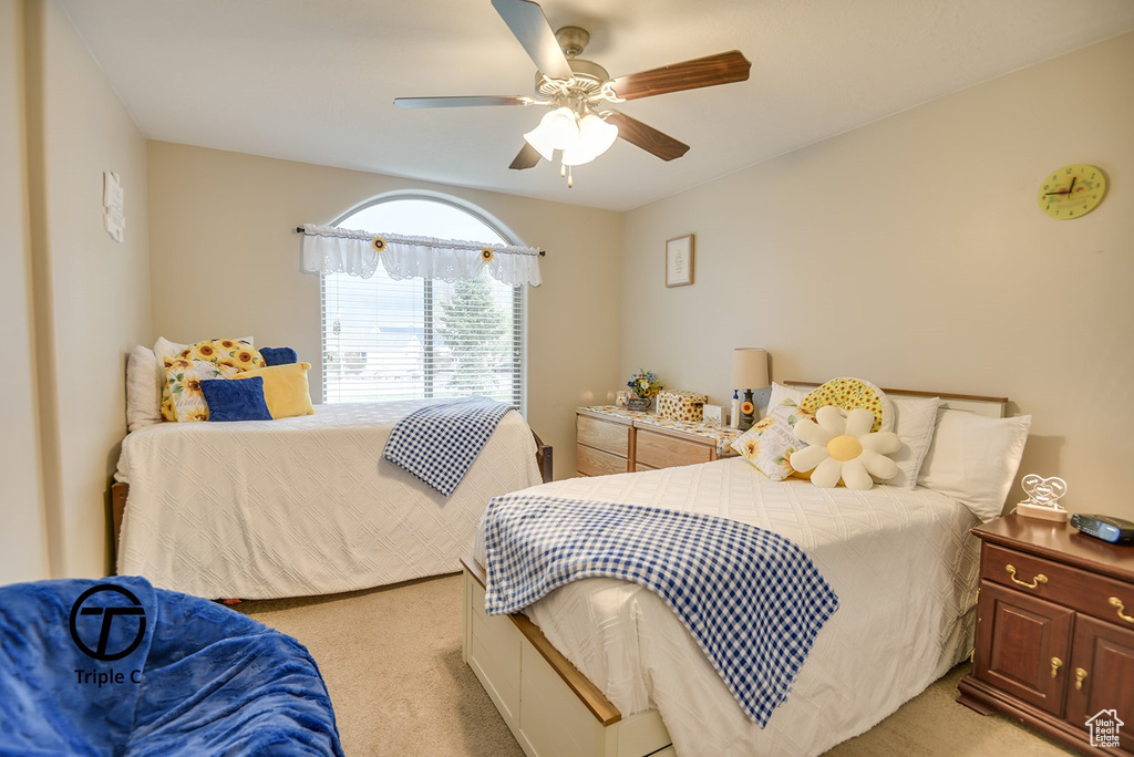 Bedroom with ceiling fan and light colored carpet