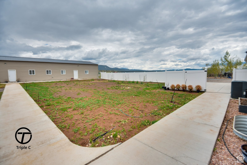 View of yard featuring fence and central AC
