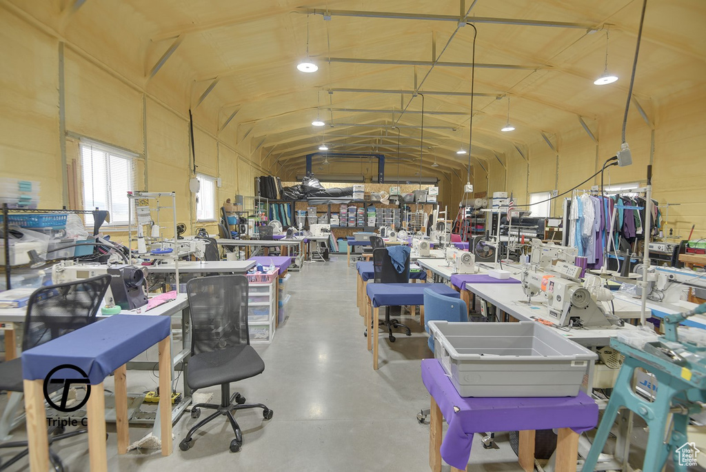 Misc room featuring lofted ceiling, a workshop area, and concrete floors
