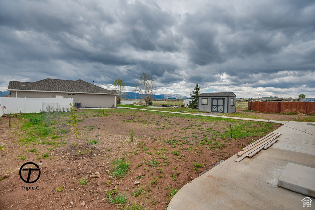 View of yard with a shed, an outdoor structure, and fence