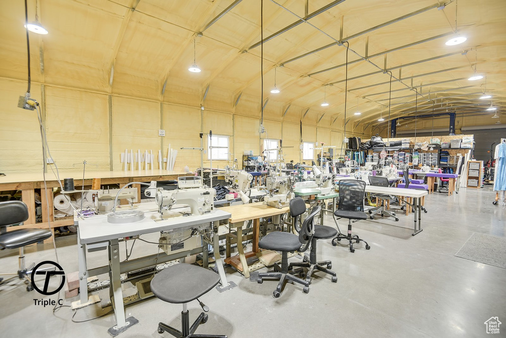 Miscellaneous room featuring a workshop area, finished concrete flooring, and vaulted ceiling