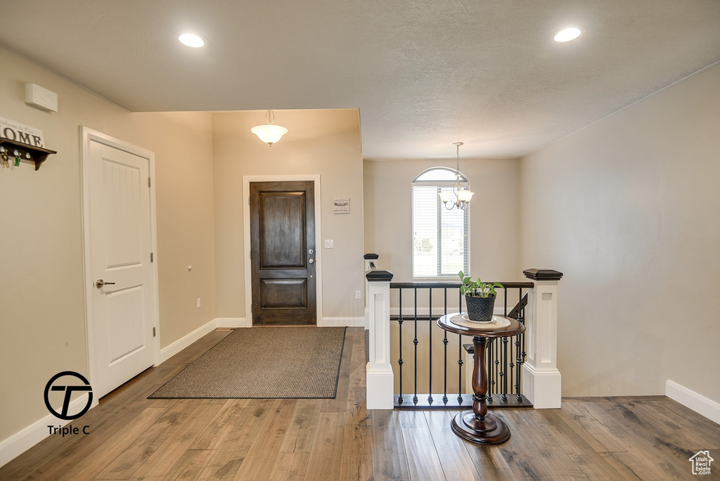 Foyer with recessed lighting, baseboards, a notable chandelier, and wood finished floors