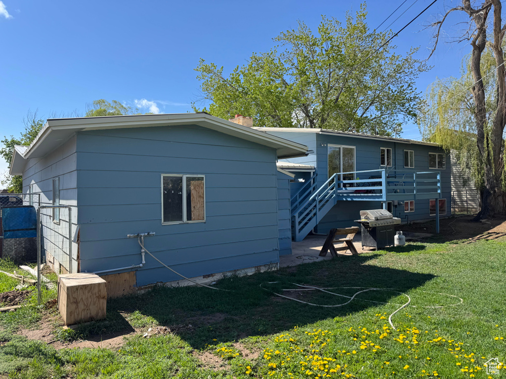Back of house with a yard, a chimney, a deck, and crawl space