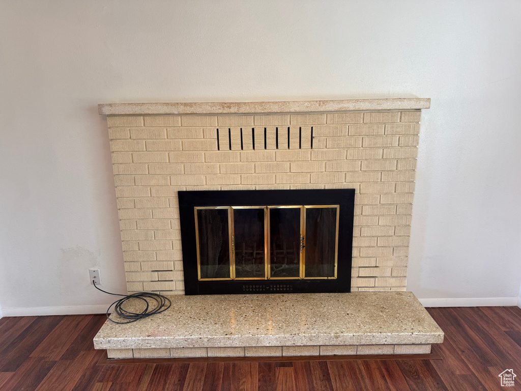 Room details with baseboards, a fireplace, and wood finished floors