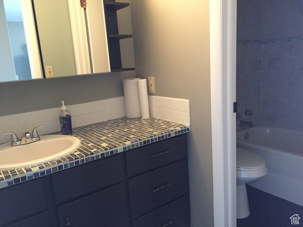 Full bathroom with toilet, vanity, and shower / washtub combination