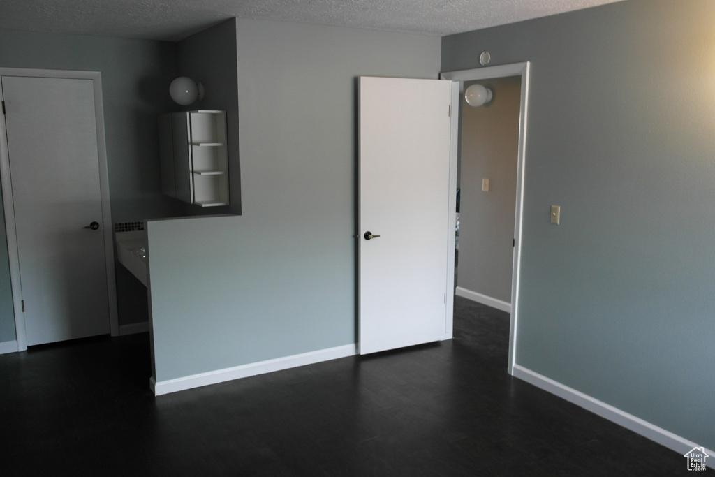 Unfurnished bedroom featuring a textured ceiling and baseboards