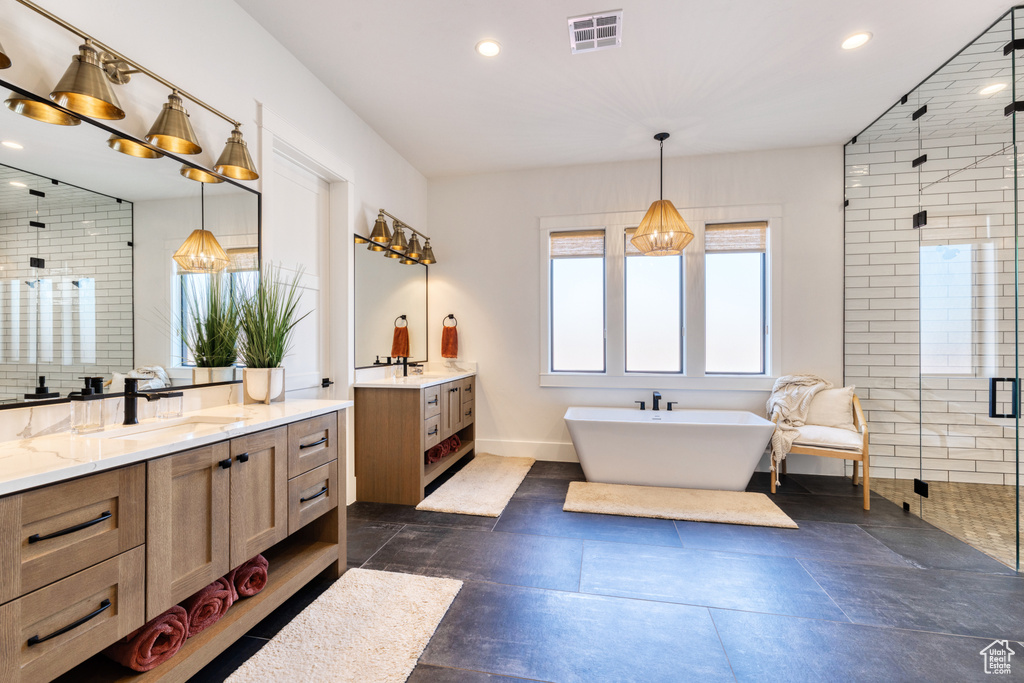 Bathroom featuring a sink, recessed lighting, a shower stall, two vanities, and visible vents