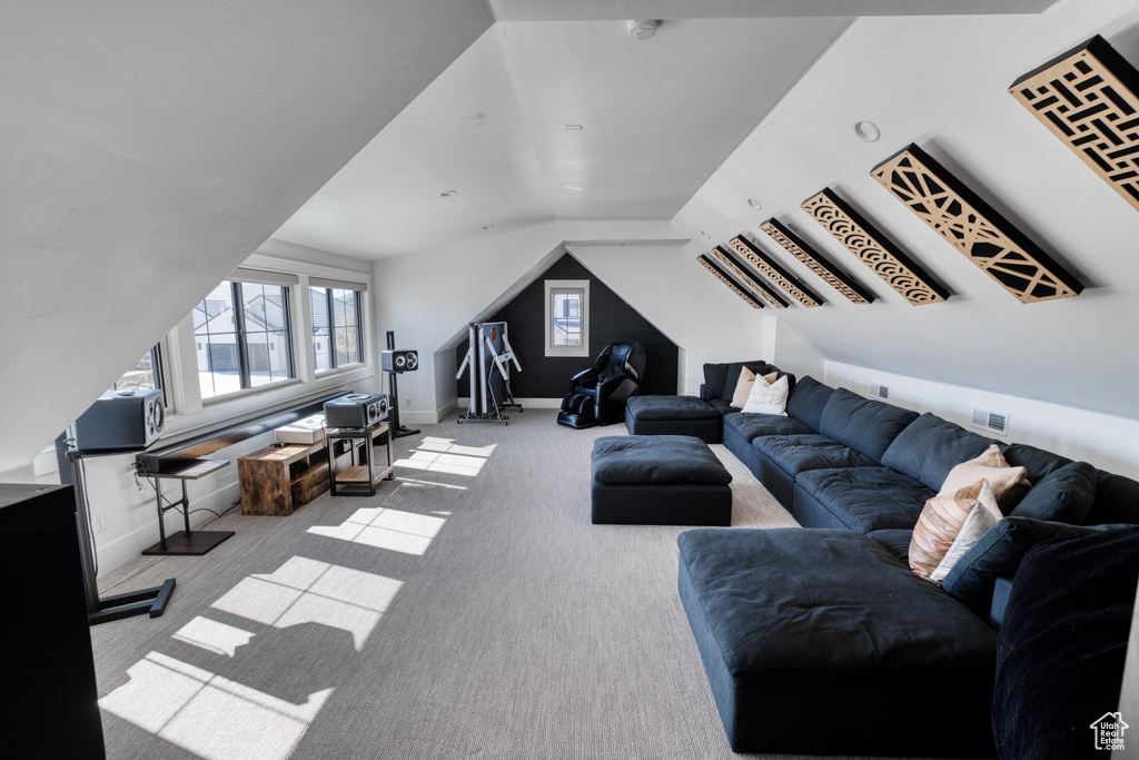 Carpeted living room featuring baseboards and lofted ceiling