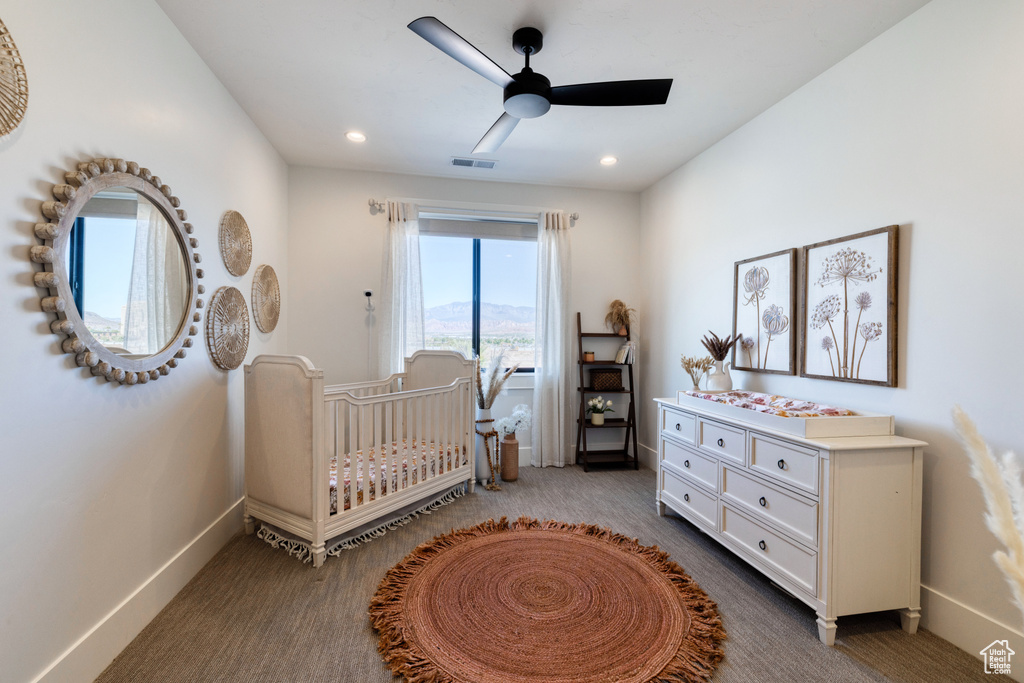 Carpeted bedroom with a nursery area, ceiling fan, recessed lighting, baseboards, and visible vents