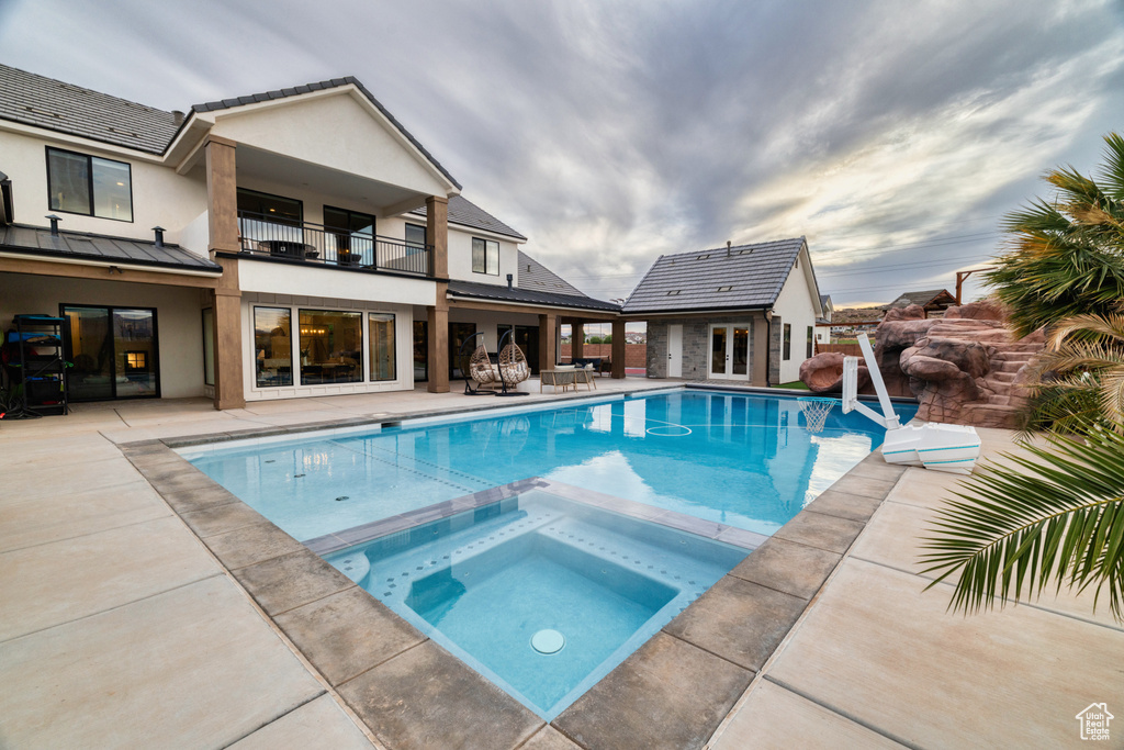 View of pool with a patio area and a pool with connected hot tub