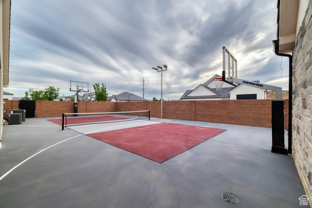 View of basketball court featuring a tennis court, fence, and community basketball court