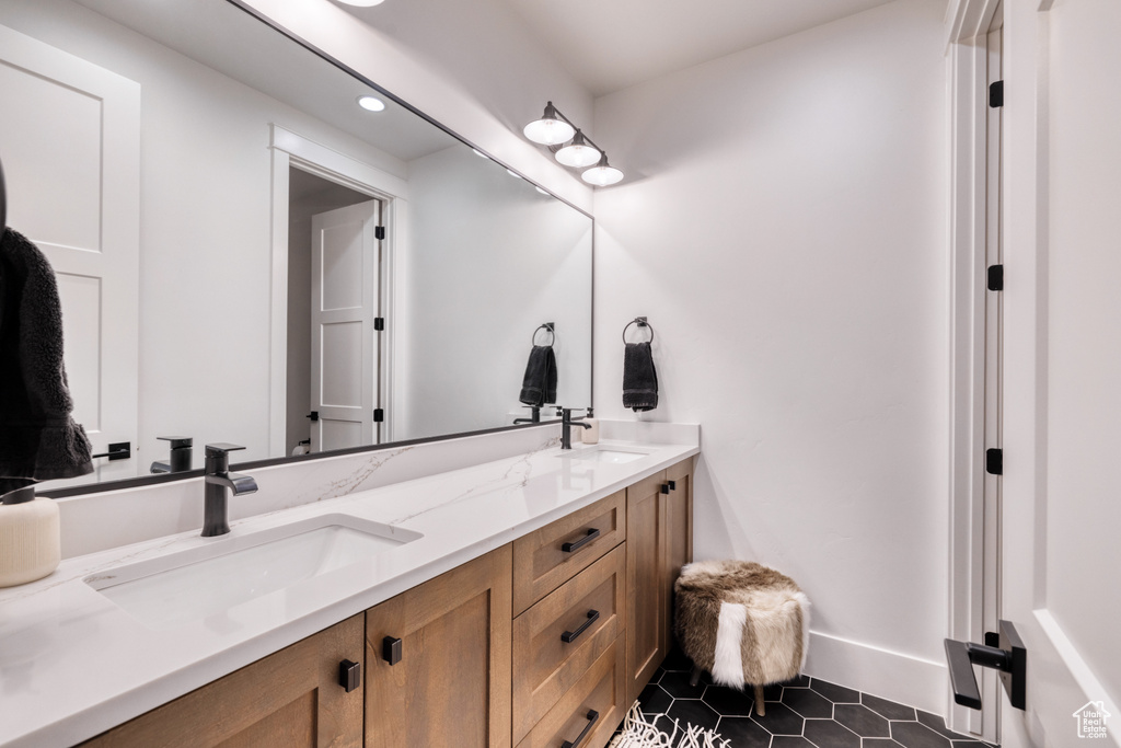 Full bathroom with double vanity, a sink, tile patterned flooring, and recessed lighting