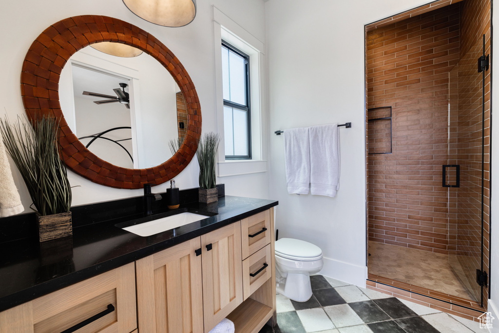 Full bathroom with vanity, toilet, tile patterned floors, a ceiling fan, and a stall shower