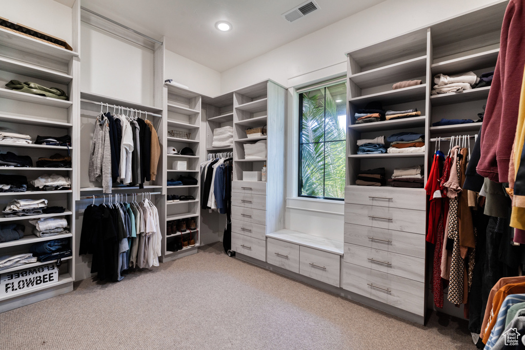 Walk in closet with visible vents and light carpet