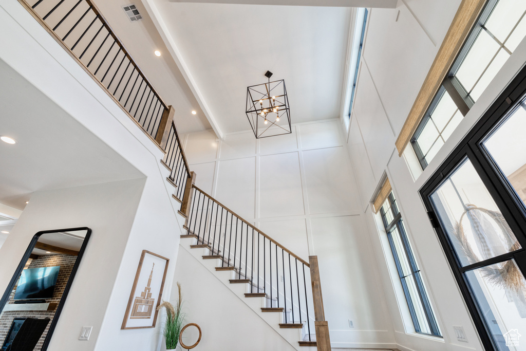 Entryway featuring a high ceiling, a notable chandelier, stairs, recessed lighting, and visible vents