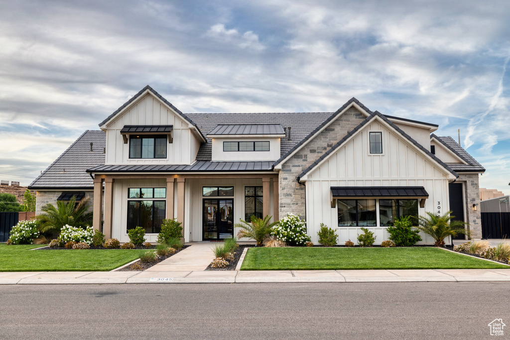 View of front of house featuring board and batten siding, a standing seam roof, and metal roof