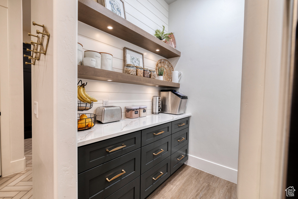 Bar featuring light wood-type flooring and baseboards