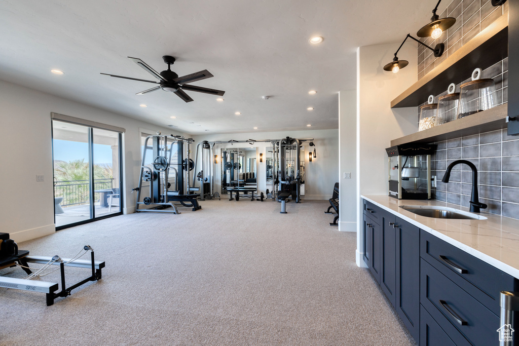Exercise room featuring recessed lighting, baseboards, light carpet, and a sink