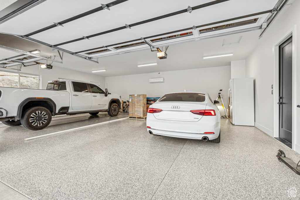 Garage with freestanding refrigerator and a garage door opener