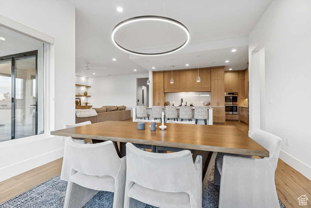 Dining room with baseboards, recessed lighting, light wood-type flooring, and a ceiling fan