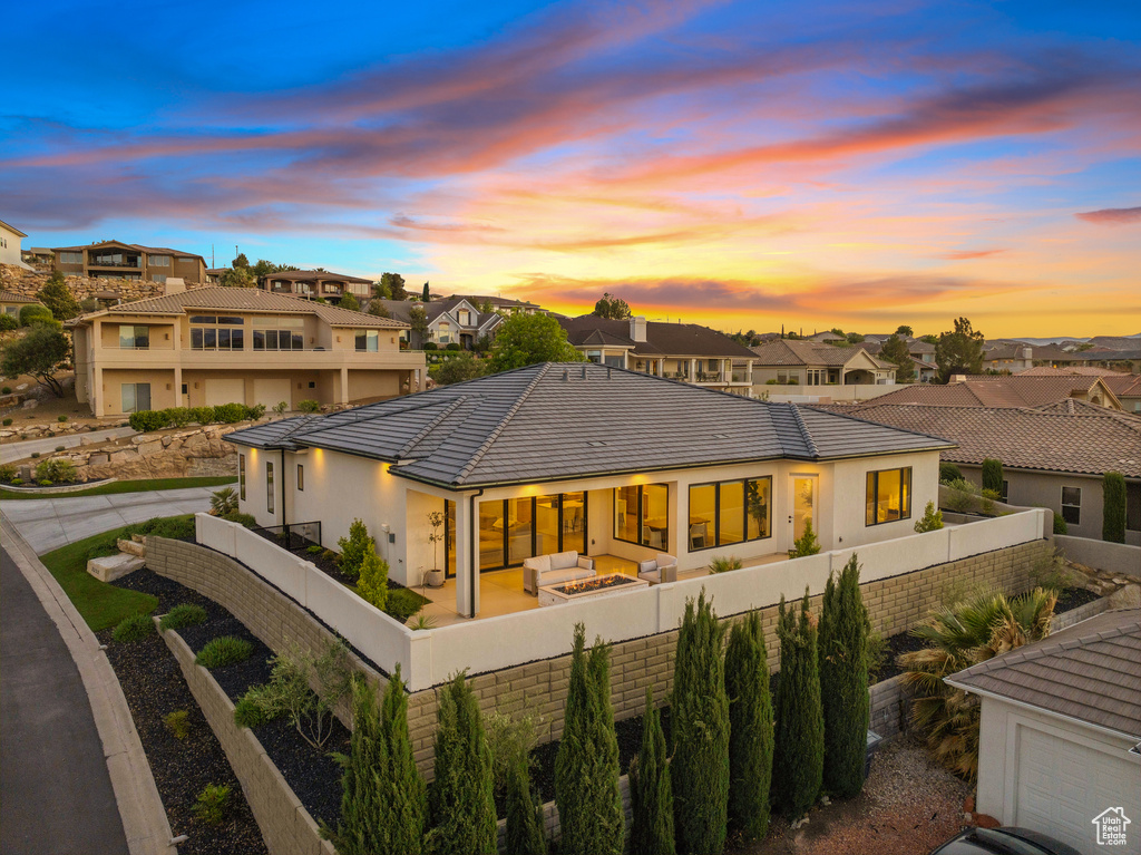 Rear view of house featuring a residential view, outdoor lounge area, stucco siding, a tile roof, and a fenced backyard