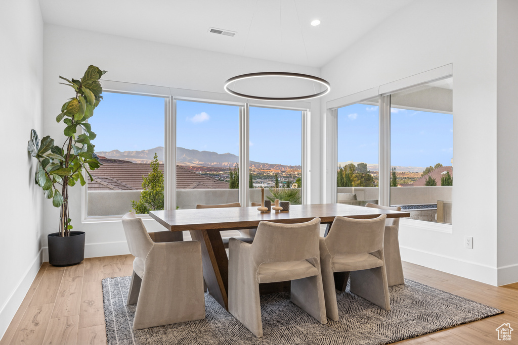 Dining room with recessed lighting, a mountain view, baseboards, visible vents, and light wood-style floors
