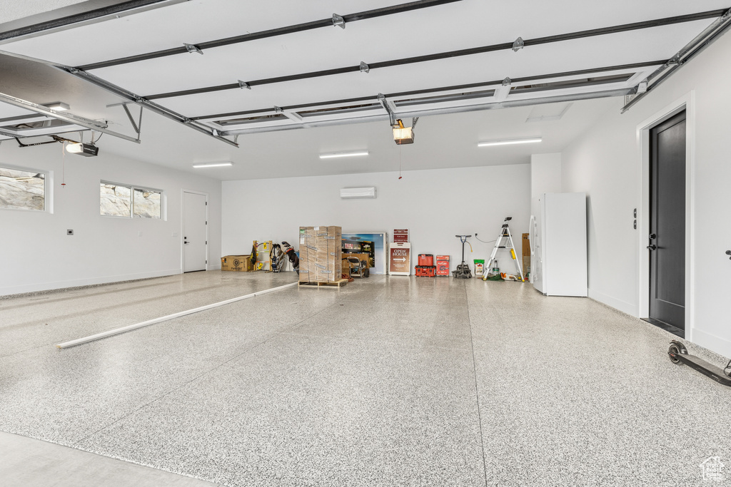 Garage with freestanding refrigerator and a garage door opener