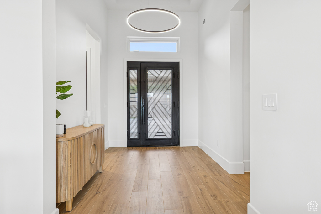 Entryway with baseboards and light wood-style flooring