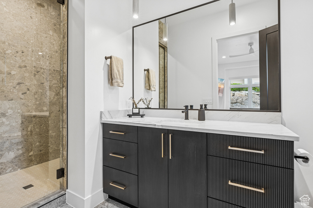 Full bathroom featuring a stall shower, vanity, and baseboards