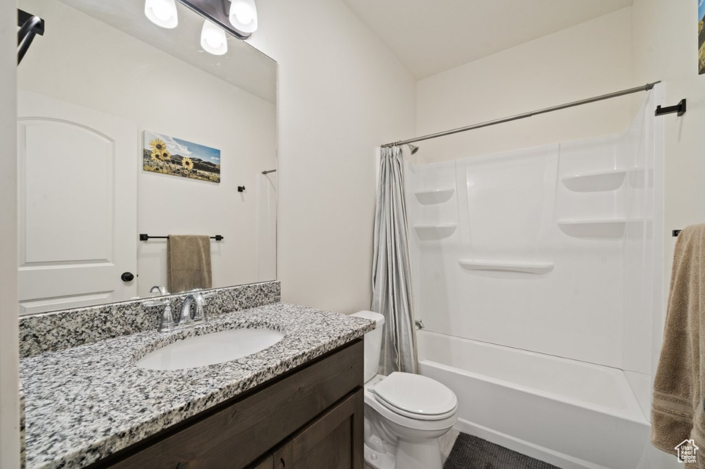 Bathroom with shower / tub combo with curtain, vanity, and toilet