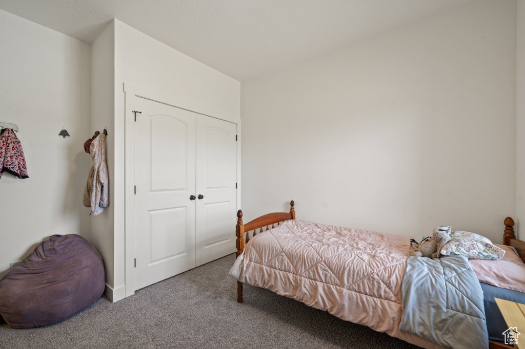 Bedroom featuring carpet flooring and a closet