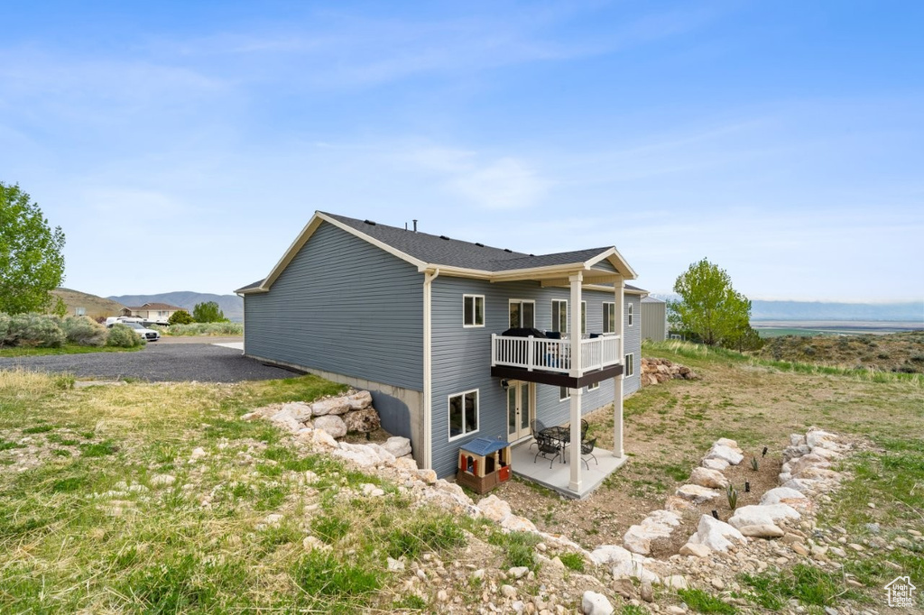 View of property exterior featuring a patio area and a deck
