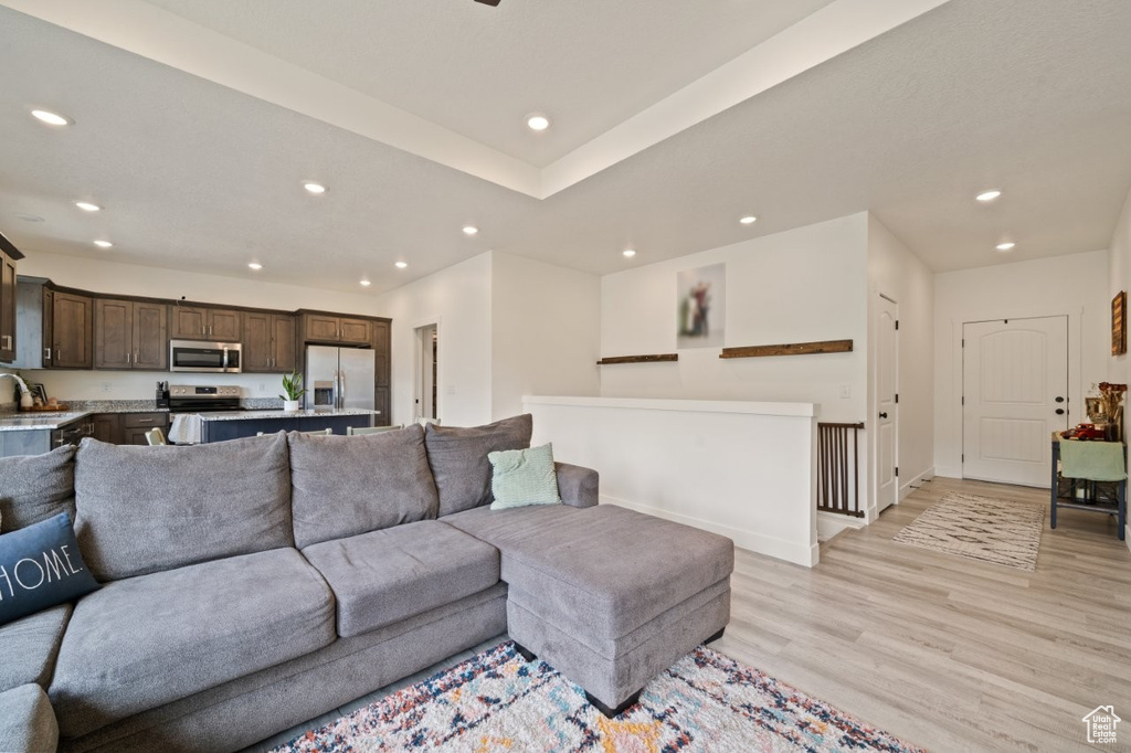 Living area featuring light wood-type flooring, baseboards, and recessed lighting