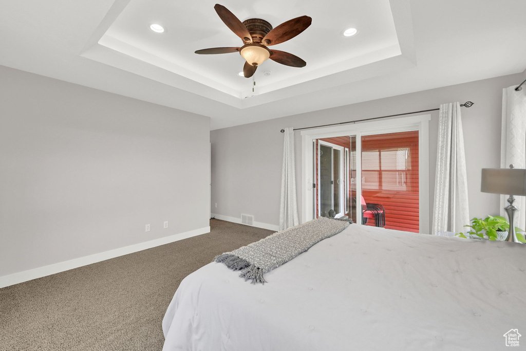 Bedroom with carpet flooring, visible vents, baseboards, a raised ceiling, and recessed lighting