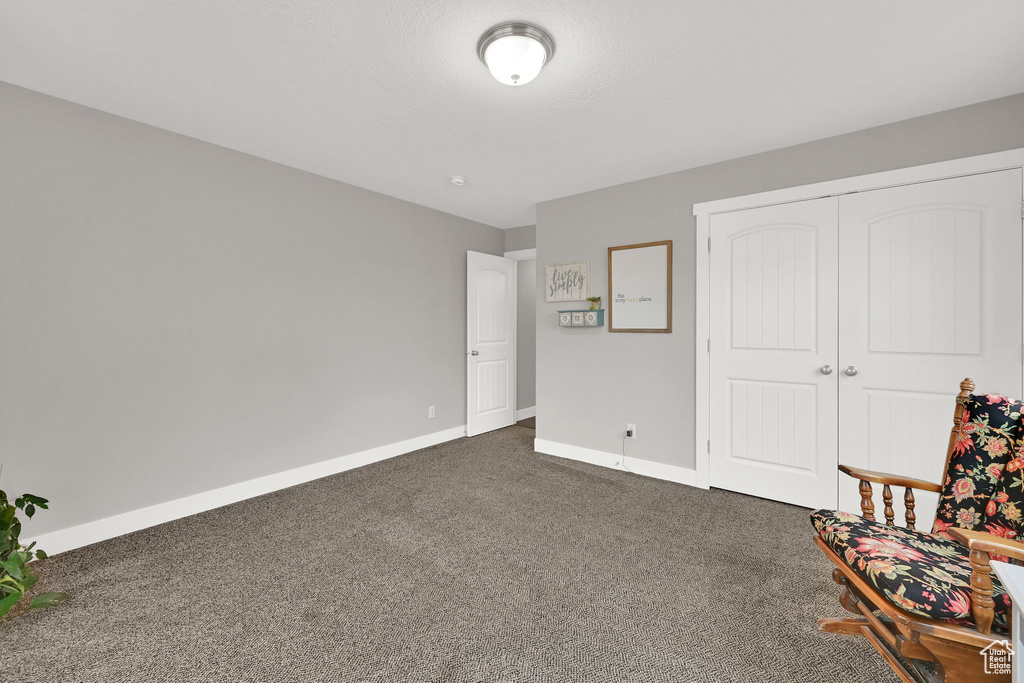 Sitting room with baseboards and dark carpet