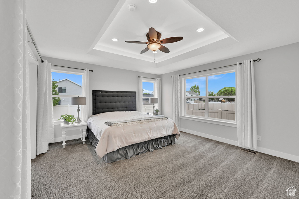Bedroom featuring a raised ceiling, carpet flooring, visible vents, and recessed lighting