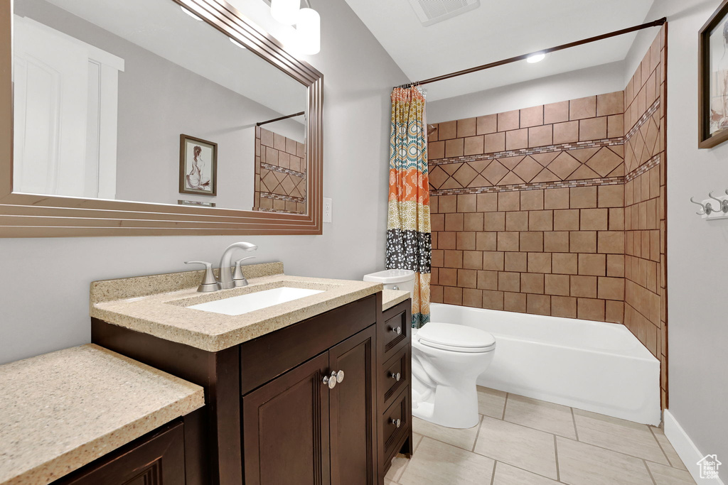 Bathroom featuring toilet, vanity, visible vents, tile patterned floors, and shower / bathtub combination with curtain