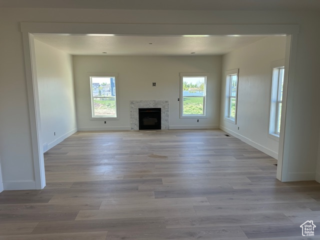 Unfurnished living room with baseboards and plenty of natural light
