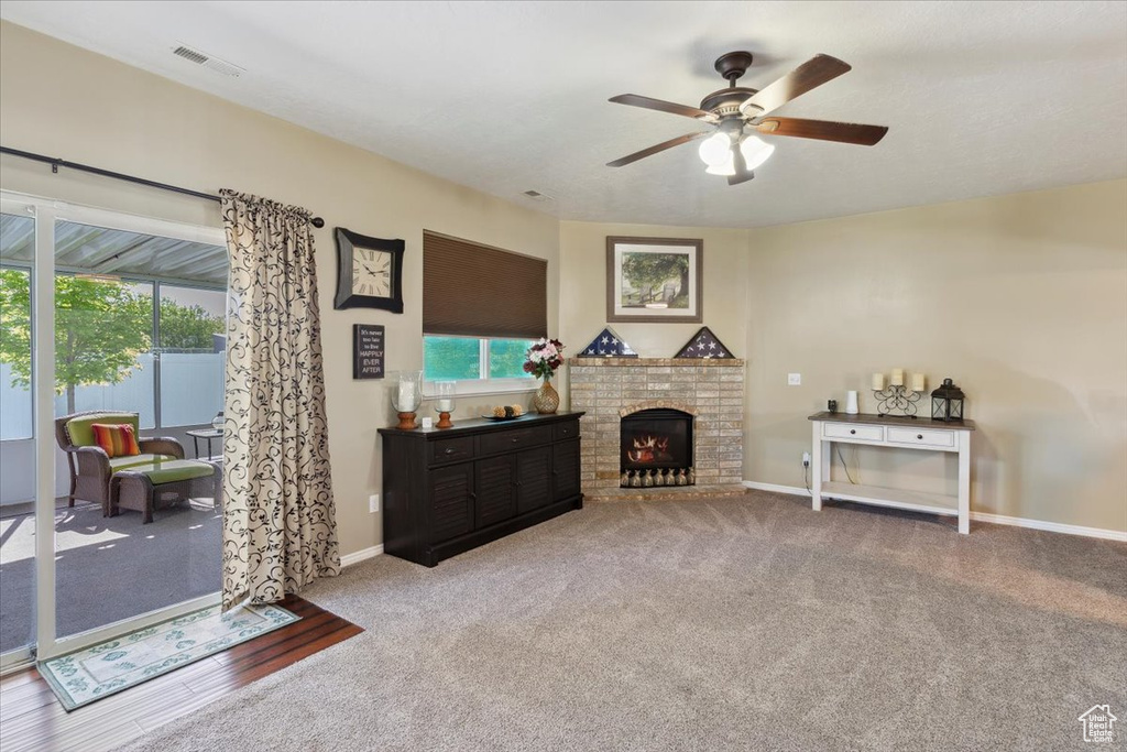 Living area with a healthy amount of sunlight, ceiling fan, and carpet floors