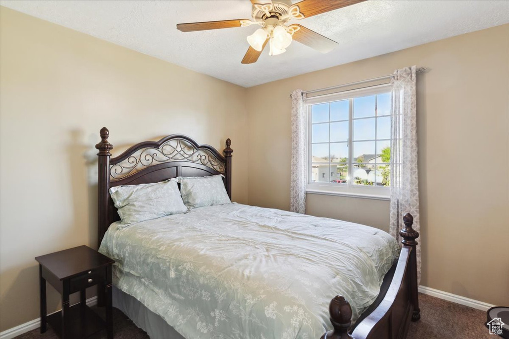 Carpeted bedroom featuring baseboards and a ceiling fan