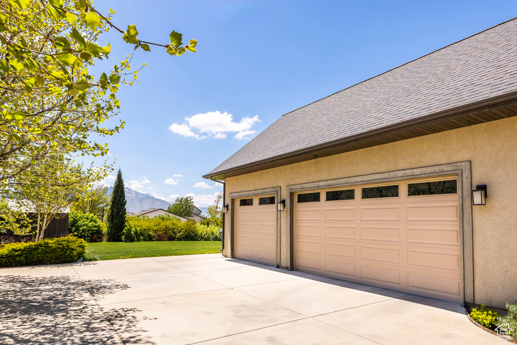 Garage with concrete driveway and a mountain view