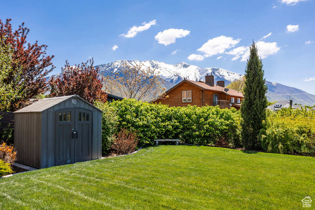 View of yard with a storage unit, an outdoor structure, and a mountain view