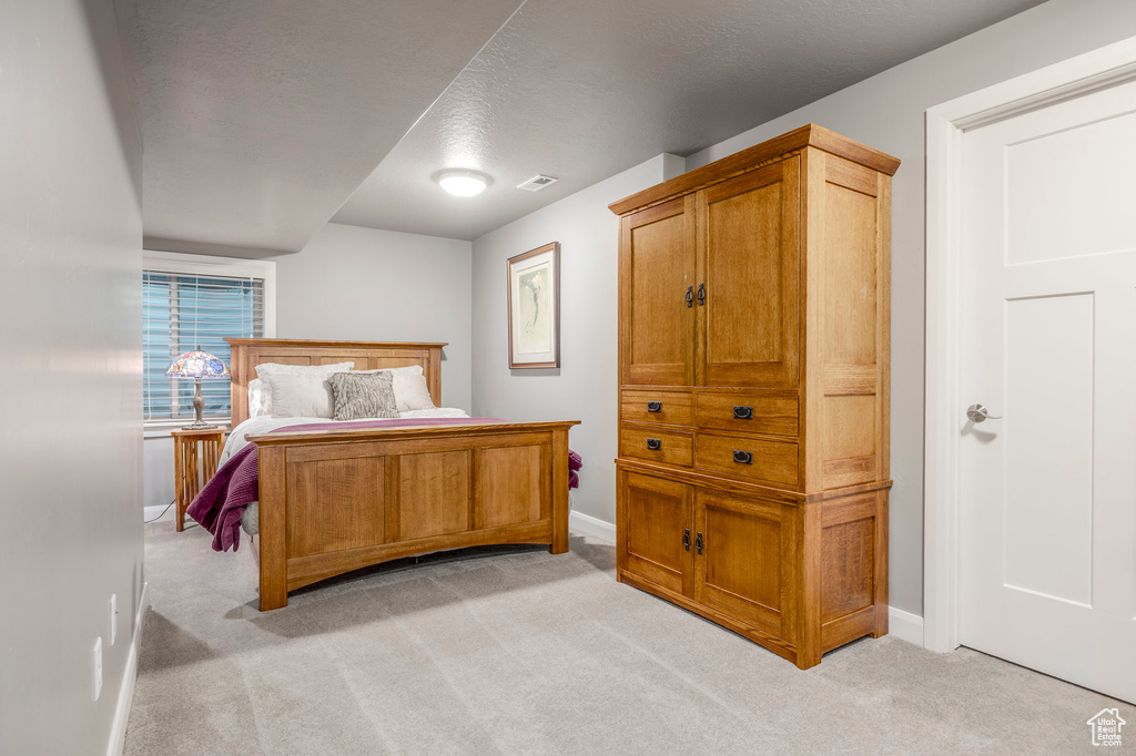 Bedroom featuring baseboards and light carpet