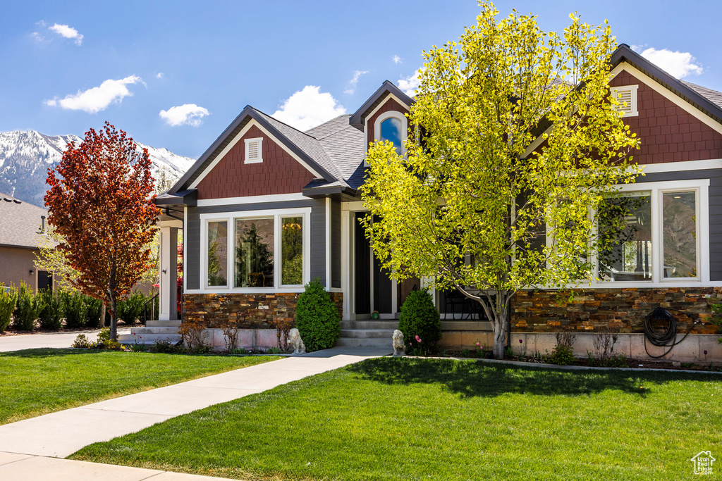 Craftsman inspired home featuring entry steps, a front lawn, and stone siding