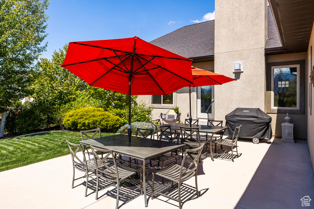 View of patio with outdoor dining space and grilling area