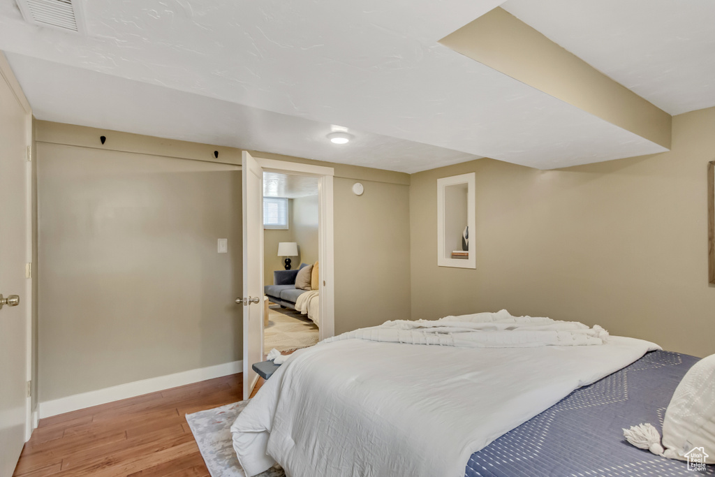 Bedroom with visible vents, light wood-style flooring, and baseboards