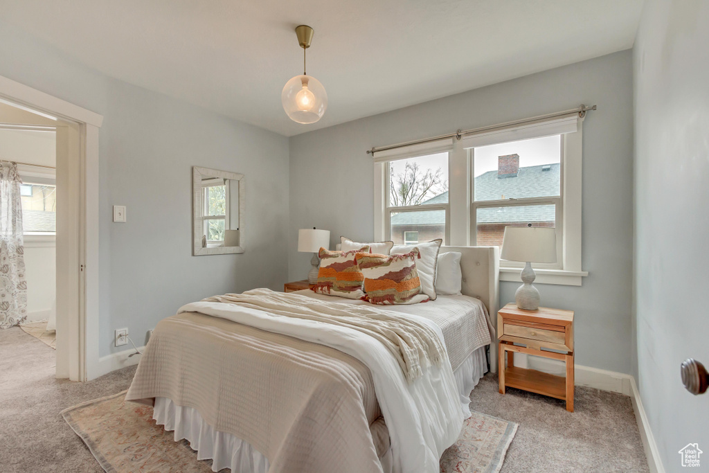 Bedroom with baseboards, multiple windows, and light carpet