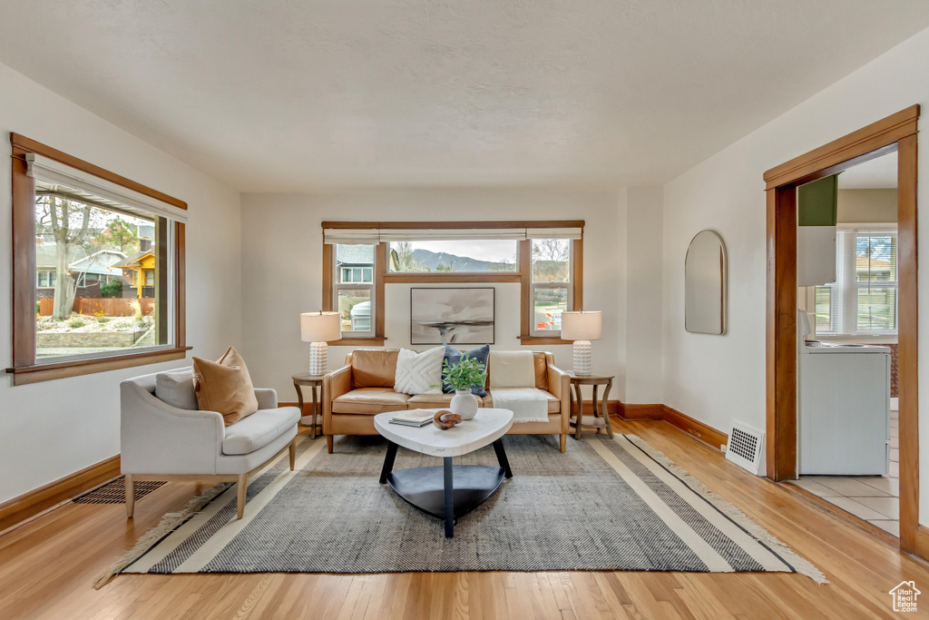Sitting room featuring visible vents, light wood-style flooring, and baseboards