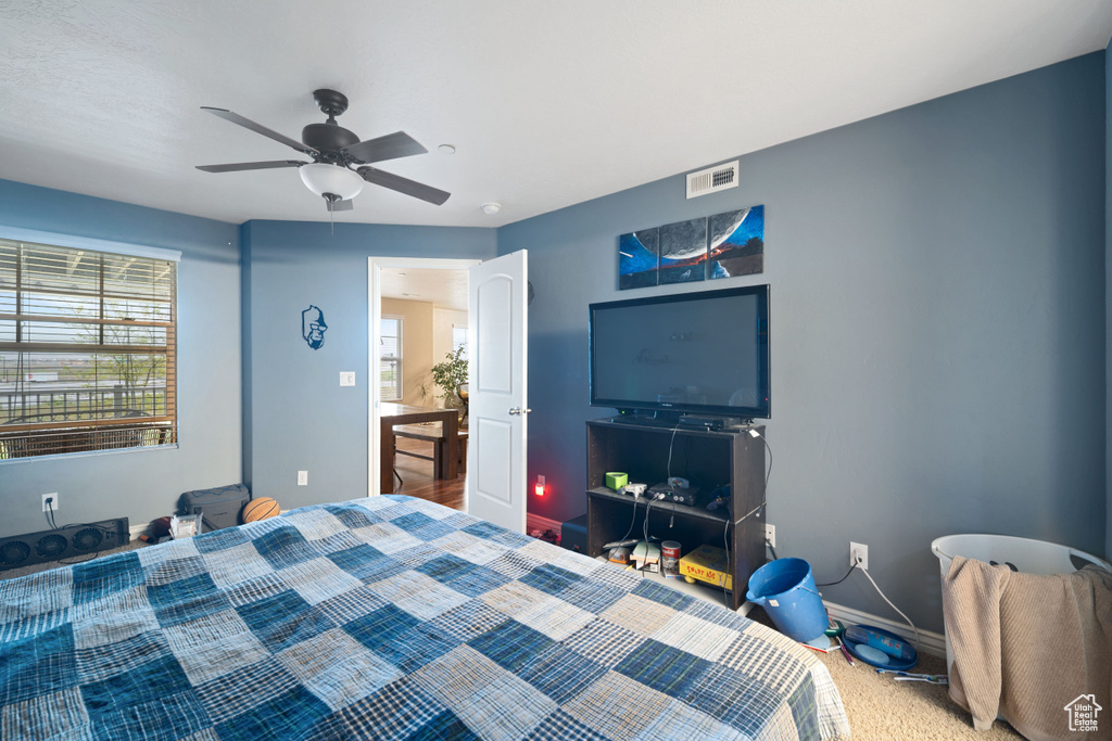 Carpeted bedroom with visible vents, baseboards, and a ceiling fan